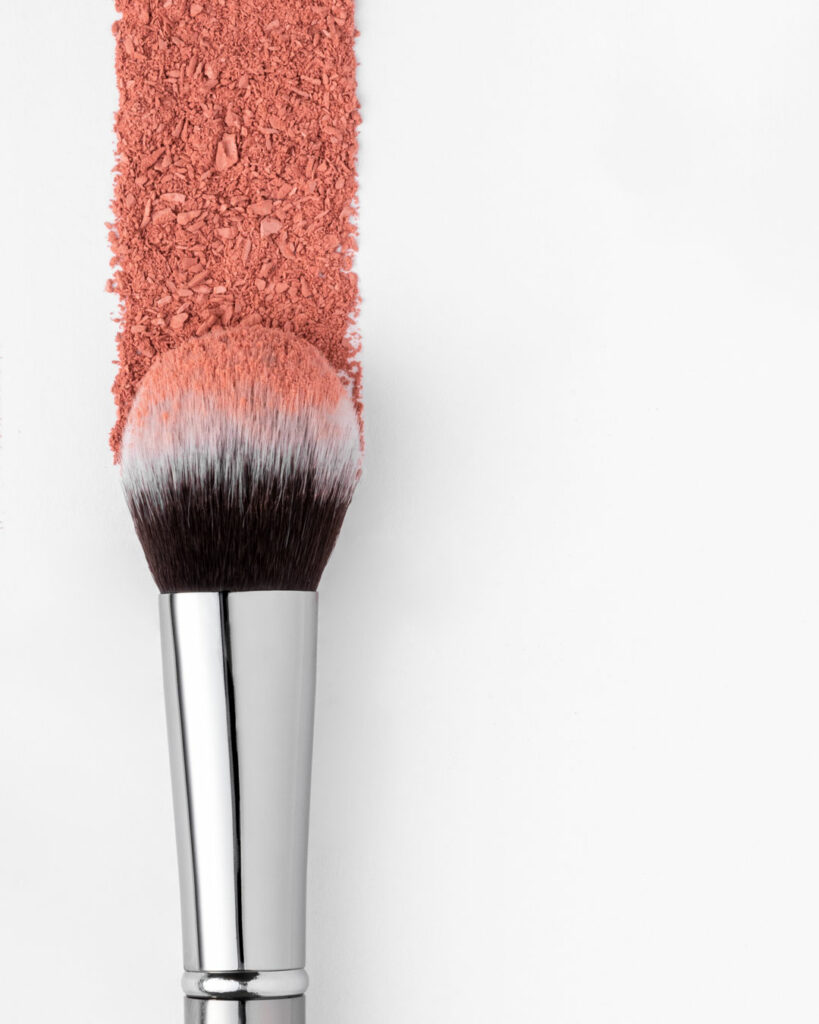 Cosmetic Beautical brush with pink powder on light grey background